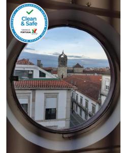 a round window with a view of a building at Fonte Branca Guest House - Sé in Braga