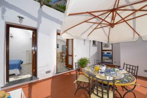 a dining room with a table and an umbrella at Casa La Verbena in Praiano