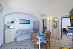 a living room with a table and a couch at Casa La Verbena in Praiano +24 photos