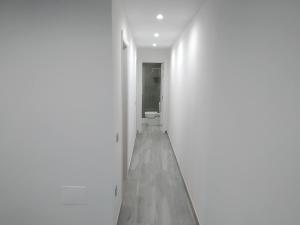 a hallway with a toilet in a white room at Jandia Suite in Morro del Jable