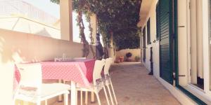 Villa ForTudor في ميلنا: طاولة مع طاولة وردية وبيضاء وكراسي على الشرفة