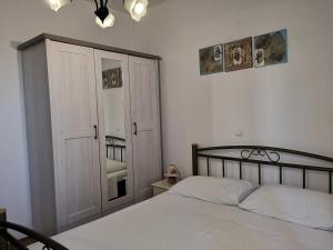 a bedroom with a bed and a closet and a window at Villa ForTudor in Milna