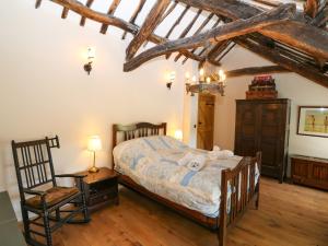 a bedroom with a bed with a teddy bear on it at Garth Morthin The Farmhouse in Porthmadog