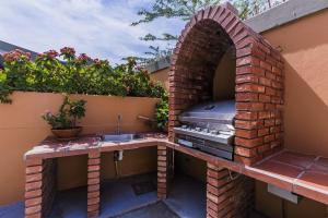 an outdoor kitchen with a sink and a brick wall at King David Suites in Palm-Eagle Beach