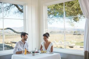 a man and woman sitting at a table with a plate of food at Carneros Resort and Spa in Napa