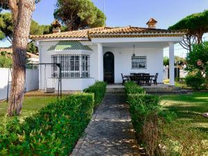una casa blanca con una puerta negra en Barrosa Playa 5, en Chiclana de la Frontera