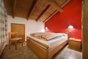 sypialnia z łóżkiem i czerwoną ścianą w obiekcie Residence Adele w Livigno
