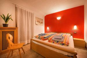 a bedroom with a bed with a red wall at Residence Adele in Livigno