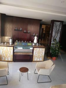 a lobby with chairs and tables and a counter at روز للوحدات السكنيه in Al Thybiyah