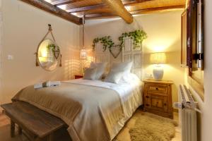 1 dormitorio con cama, mesa y banco en Casa Rural A Cashiña da Lagarteira en Valverde del Fresno