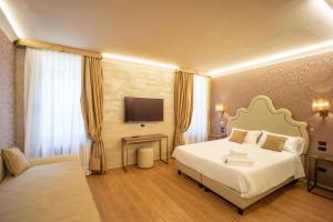 ein Hotelzimmer mit einem Bett und einem TV in der Unterkunft Locanda Cavanella in Venedig
