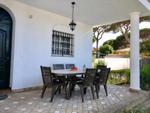 un patio con mesa de comedor y sillas en Barrosa Playa 5, en Chiclana de la Frontera