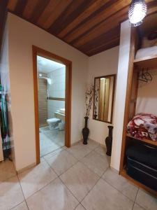 a room with a bathroom with a toilet and a mirror at Chalé Sonho Meu in Monte Verde