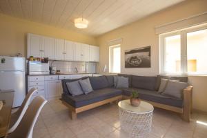 a living room with a couch and a kitchen at Golden Sun Apartments in Kókkinos Pírgos