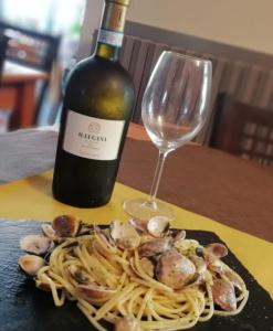 a plate of pasta with shrimp and a bottle of wine at Albergo Torino in Albenga