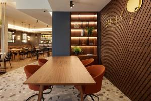 a restaurant with a wooden table and chairs at Hotel SANSEbay in Donostia-San Sebastián
