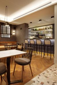 a restaurant with tables and chairs and a bar at Hotel SANSEbay in Donostia-San Sebastián