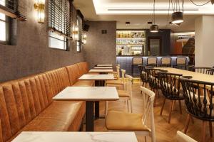 a restaurant with wooden tables and chairs and a bar at Hotel SANSEbay in Donostia-San Sebastián