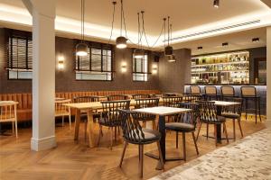 a restaurant with tables and chairs and a bar at Hotel SANSEbay in Donostia-San Sebastián