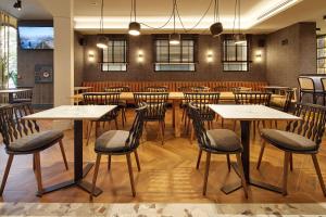 a restaurant with tables and chairs in a room at Hotel SANSEbay in Donostia-San Sebastián