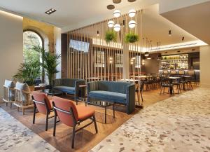 a restaurant with chairs and tables in a lobby at Hotel SANSEbay in Donostia-San Sebastián