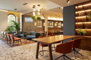 a restaurant with a wooden table and chairs at Hotel SANSEbay in Donostia-San Sebastián