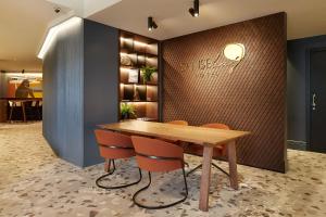 a dining room with a wooden table and orange chairs at Hotel SANSEbay in San Sebastián