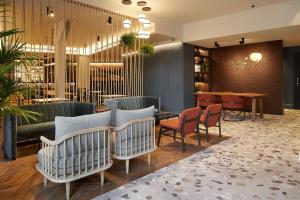 a restaurant with chairs and tables in a lobby at Hotel SANSEbay in Donostia-San Sebastián