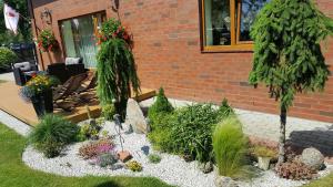 a garden in front of a house with plants at Žuvėdrų kiemelis in Šventoji