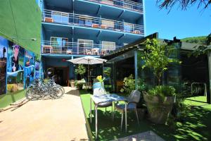 een patio met een tafel en stoelen en een parasol bij Pensión Hostel Costa Brava in L'Estartit