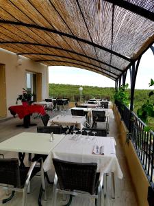 un restaurant avec des tables et des chaises et un grand plafond dans l'établissement Hôtel Le Valaurie, à Saint-Nazaire