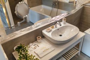uma casa de banho com um lavatório, um espelho e uma banheira em Boutique Hotel Capitano em Herceg-Novi