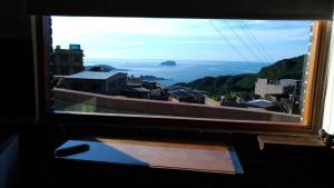 a view of a city from a window at 九份山海灣民宿 I 近老街 l 海景檜木房 in Jiufen