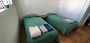 2 łóżka w pokoju z zieloną pościelą i poduszkami w obiekcie Golf & Beach La Alcaidesa Terrace w mieście San Roque +14 zdjęć