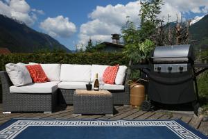 a white couch sitting on a patio with a grill at Chamonix Large Chalet, Sleeps 12, 200m2, 5 Bedroom, 4 Bathroom, Garden, Jacuzzi, Sauna in Chamonix