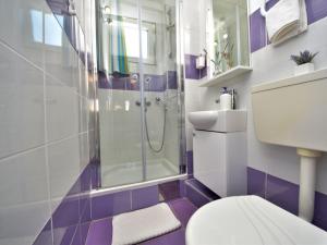 y baño blanco y morado con ducha y aseo. en Holiday Home Ena , Mali Iž 286 en Mali Iž