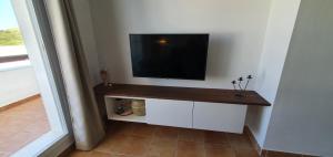 telewizor z płaskim ekranem na ścianie w pokoju w obiekcie Golf & Beach La Alcaidesa Terrace w mieście San Roque
