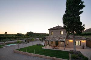 a large house with a tree and a yard at Casa Clotilde in Alcañiz
