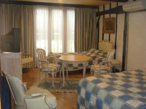 a hotel room with a bed and a table and chairs at Les Wyllos in Thiéblemont-Farémont