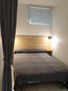 a bedroom with a bed with a window and a curtain at Studio Balaruc les Bains, vue sur l'étang de Thau classement 2 étoiles in Balaruc-les-Bains