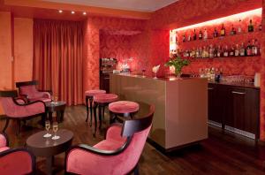 un bar in un ristorante con sedie rosa e un bancone di c-hotels Fiume a Roma