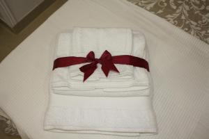 卡斯特拉玛雷帝斯达比亚Le Stanze di Eli e Giò的床上的白色毛巾和红色的蝴蝶结 更多33张照片