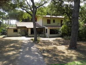 a house with two trees in front of it at Vacanza nella Natura in Punta Ala