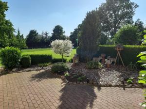 a garden with a brick walkway and a garden with a tree at Ferienwohnung Heck in Waldeck