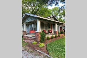 a home with a front porch with red chairs at Mill Cottage in Tupelo