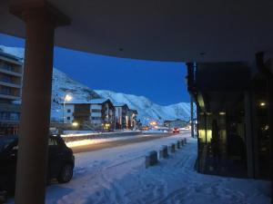 庫哈台的住宿－Gasthof Schöne Aussicht，一条雪 ⁇ 的街道,在晚上与群山相伴