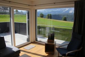 een woonkamer met een groot raam met uitzicht bij Ski In/Ski Out Appartement Jagahütt'n by Schladmingurlaub in Schladming