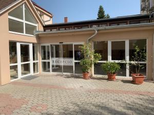 a building with potted plants in front of it at Oázis Panzió**** in Nagykanizsa