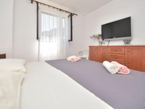 a bedroom with a bed with pink and white towels on it at Holiday Home Ena , Mali Iž 286 in Mali Iž