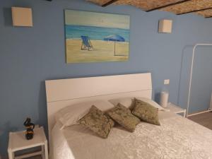a bedroom with a bed with a painting on the wall at A casa di Ninuccia in Syracuse